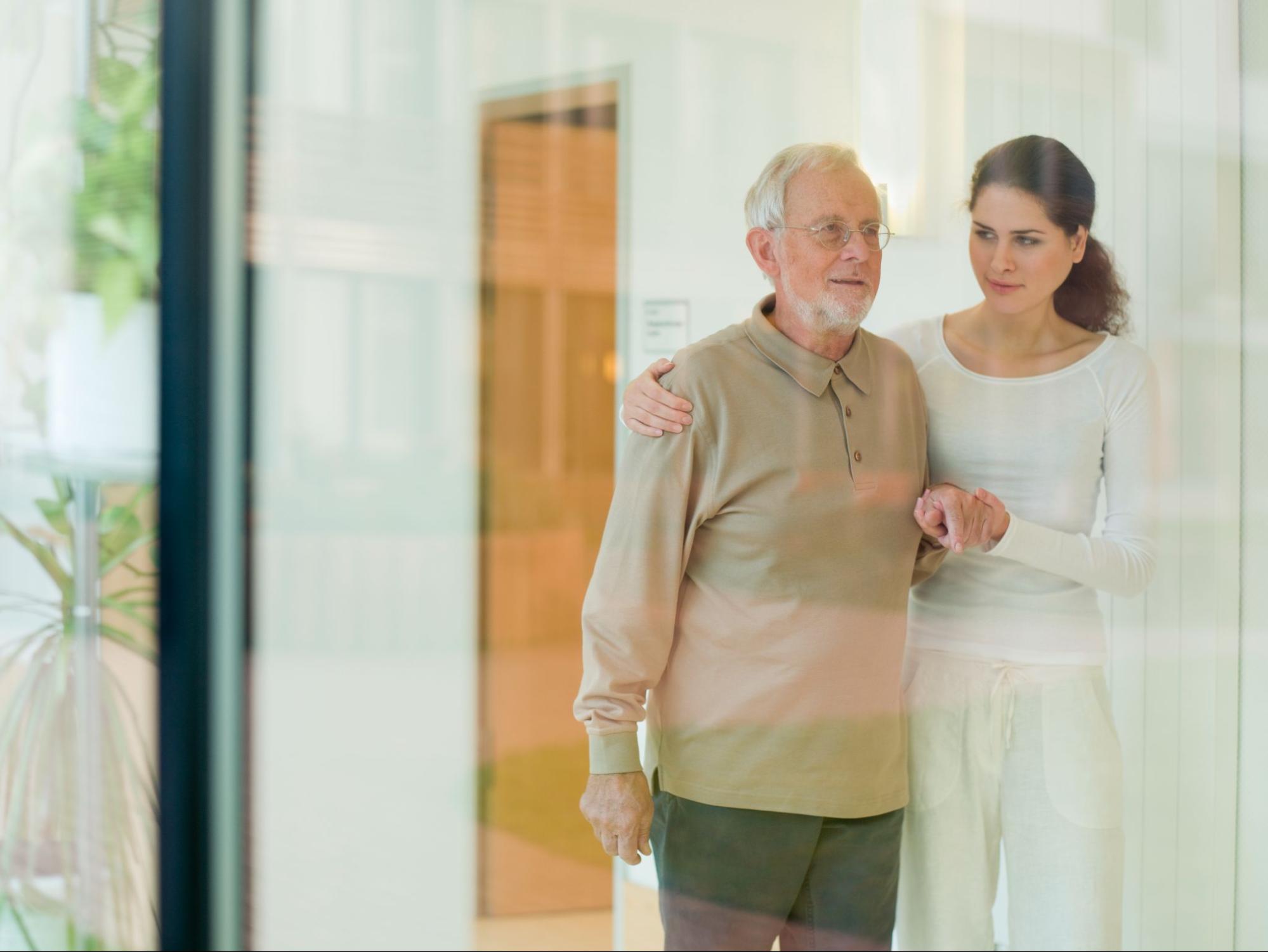 femaile-caregiver-that-would-benefit-from-respite-care-in-providing-help-walking-to-father